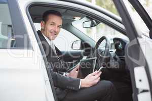 Businessman working in the drivers seat