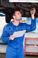 Mechanic examining under the car