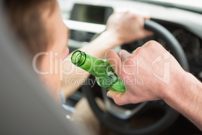 Man drinking beer while driving