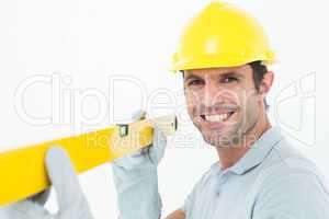 Confident male carpenter holding spirit level