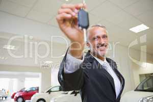 Salesman standing while offering car keys