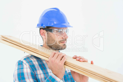 Confident carpenter carrying wooden planks