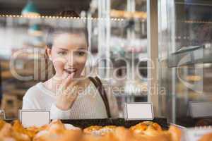 Pretty brunette looking at pastrys