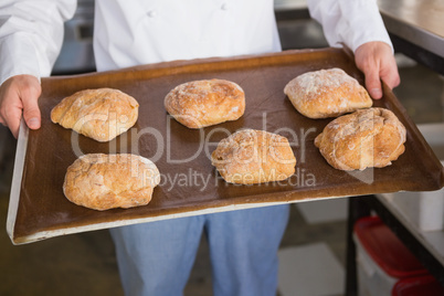 Close up of baker showing tray with bread