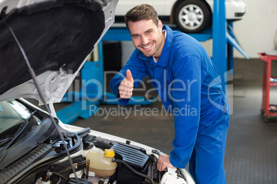 Mechanic examining under hood of car