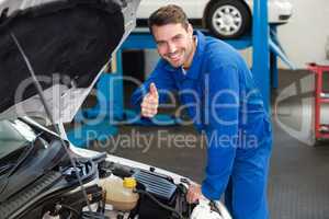 Mechanic examining under hood of car