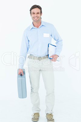 Confident supervisor carrying tool box and clipboard