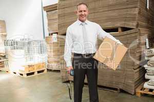 Warehouse manager holding cardboard box and scanner