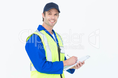 Handsome supervisor writing notes on clipboard