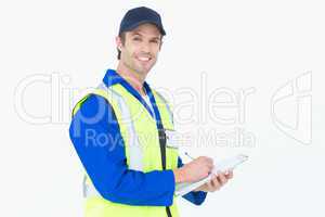 Handsome supervisor writing notes on clipboard