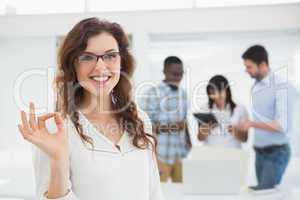 Smiling businesswoman making okay gesture