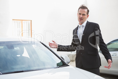 Businessman looking his car engine after breaking down