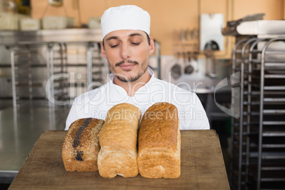 Smiling baker showing loaves of bread