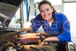 Mechanic smiling at the camera with torch