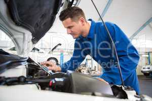 Mechanic using tablet to fix car