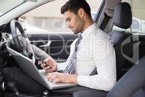 Businessman working in the drivers seat