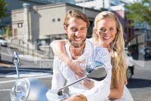 Attractive couple riding a scooter