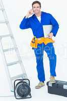 Electrician with leg on tool box using mobile phone