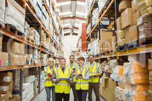 Smiling warehouse team looking at camera