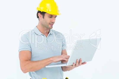 Handsome male carpenter holding laptop