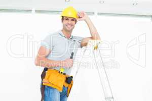 Technician holding hammer while wearing hard hat on step ladder