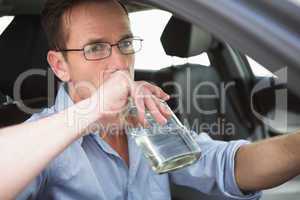 Man drinking wine while driving