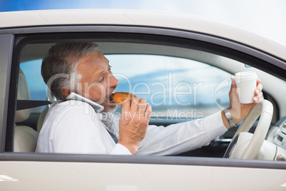 Man drinking coffee and eating donnut on phone