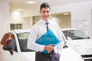 Man standing with hand in pocket while holding folder