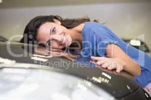 Smiling woman hugging a black car