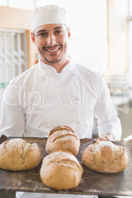 Happy baker showing tray of fresh bread Happy baker showing tray of fresh bread