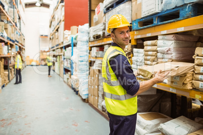 Warehouse worker taking package in the shelf