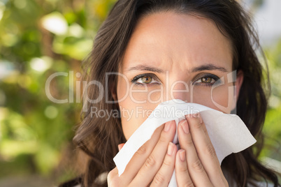 Pretty brunette blowing her nose