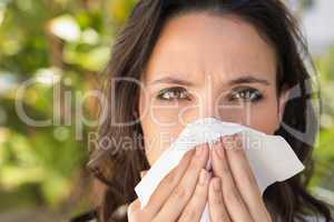 Pretty brunette blowing her nose