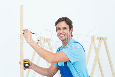 Portrait of carpenter marking on wood