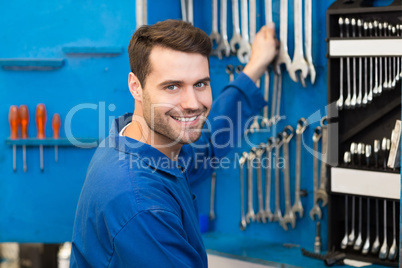 Mechanic taking a tool from wall