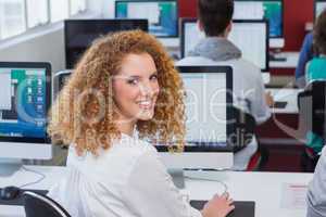 Student smiling at camera in computer class