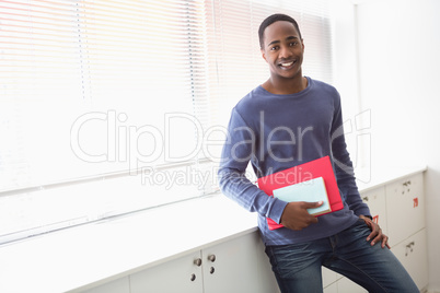 Smiling university student holding notebooks