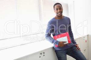 Smiling university student holding notebooks