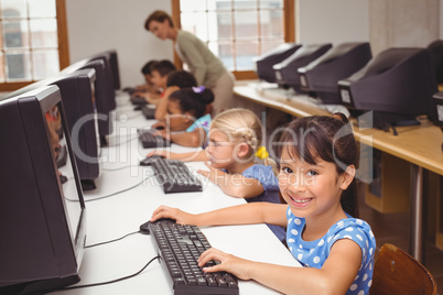 Cute pupils in computer class with teacher