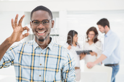 Positive businessman making okay gesture