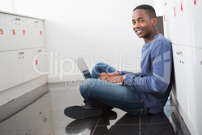 Smiling university student using laptop