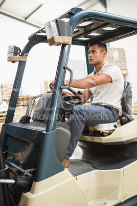 Driver operating forklift machine in warehouse