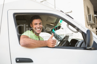 Smiling man showing thumbs up driving his van