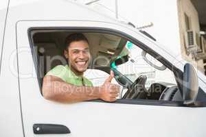 Smiling man showing thumbs up driving his van