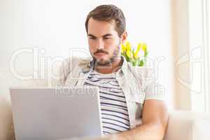 Hipster man using laptop on couch