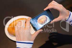 Young woman taking a photo of her lunch