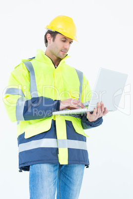 Architect in reflective clothing using laptop computer