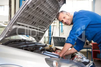 Mechanic using diagnostic tool on engine