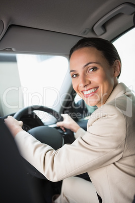 Pretty businesswoman smiling and driving