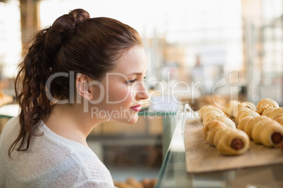 Woman eyeing up tray of pastrys
